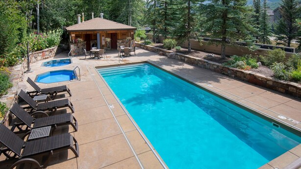 A rectangular swimming pool with lounge chairs and a small building with a roof. - Sun Vail 12e, 2BD Condo With Vail Mountain Views (Vail)