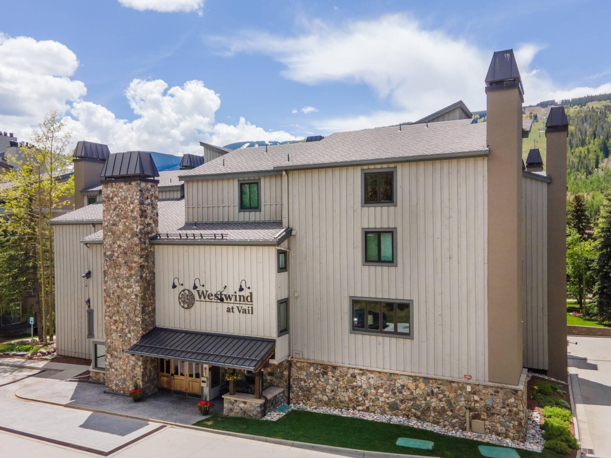 A building with a stone facade, multiple windows, and a sign reading 'Westwind at Vail'.