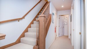 A carpeted staircase with wooden handrails and a landing area. - Aspenwood 301, 3BD Condo in Arrowhead (Edwards)