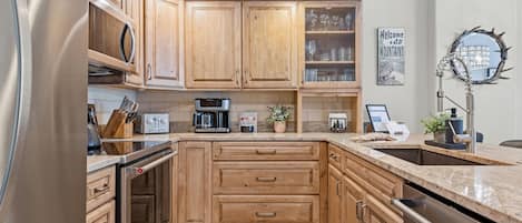 Una cocina moderna con armarios de madera, electrodomésticos de acero inoxidable y encimera de granito.