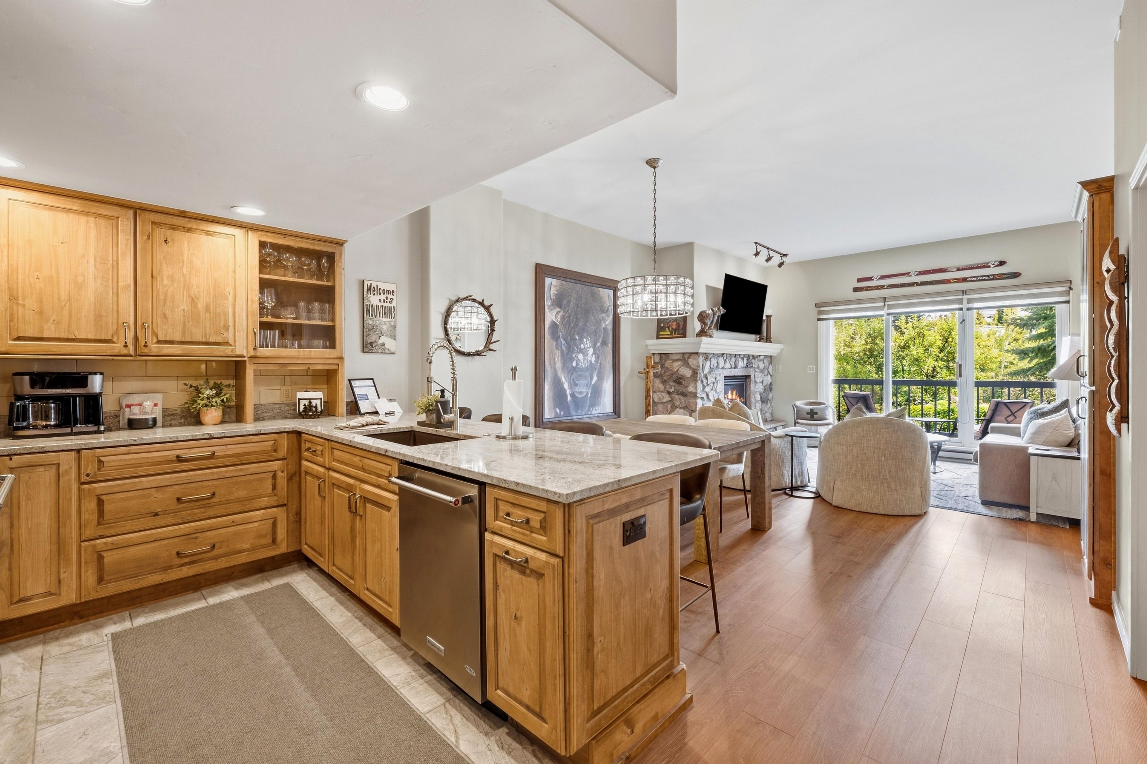 A spacious kitchen with wooden cabinets, a large island, and a dining area with a fireplace.