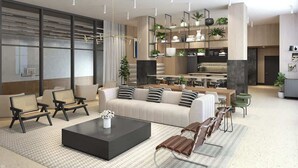 Una sala de estar moderna con sofá, mesa de centro y sillas, un área de cocina con mesa de comedor, y un ventanal con persianas.