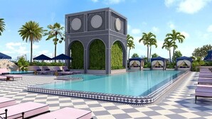 A pool area with lounge chairs, a decorative pool edge, and a building with arches and greenery. - Luxury Wynwood 1BR with Rooftop Pool & Gym (Miami)