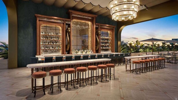 An outdoor bar area with a long counter, multiple stools, and a large chandelier. - Luxury Wynwood 1BR with Rooftop Pool & Gym (Miami)