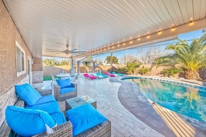 An outdoor pool area with lounge chairs and a covered patio. - family-friendly home games & pool (Las Vegas)