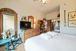 A bedroom with a bed, dresser, television, and a chair with fur. - Borders Lodge L109 2BD Beaver Creek Ski-in, Ski-out Condo (Avon)