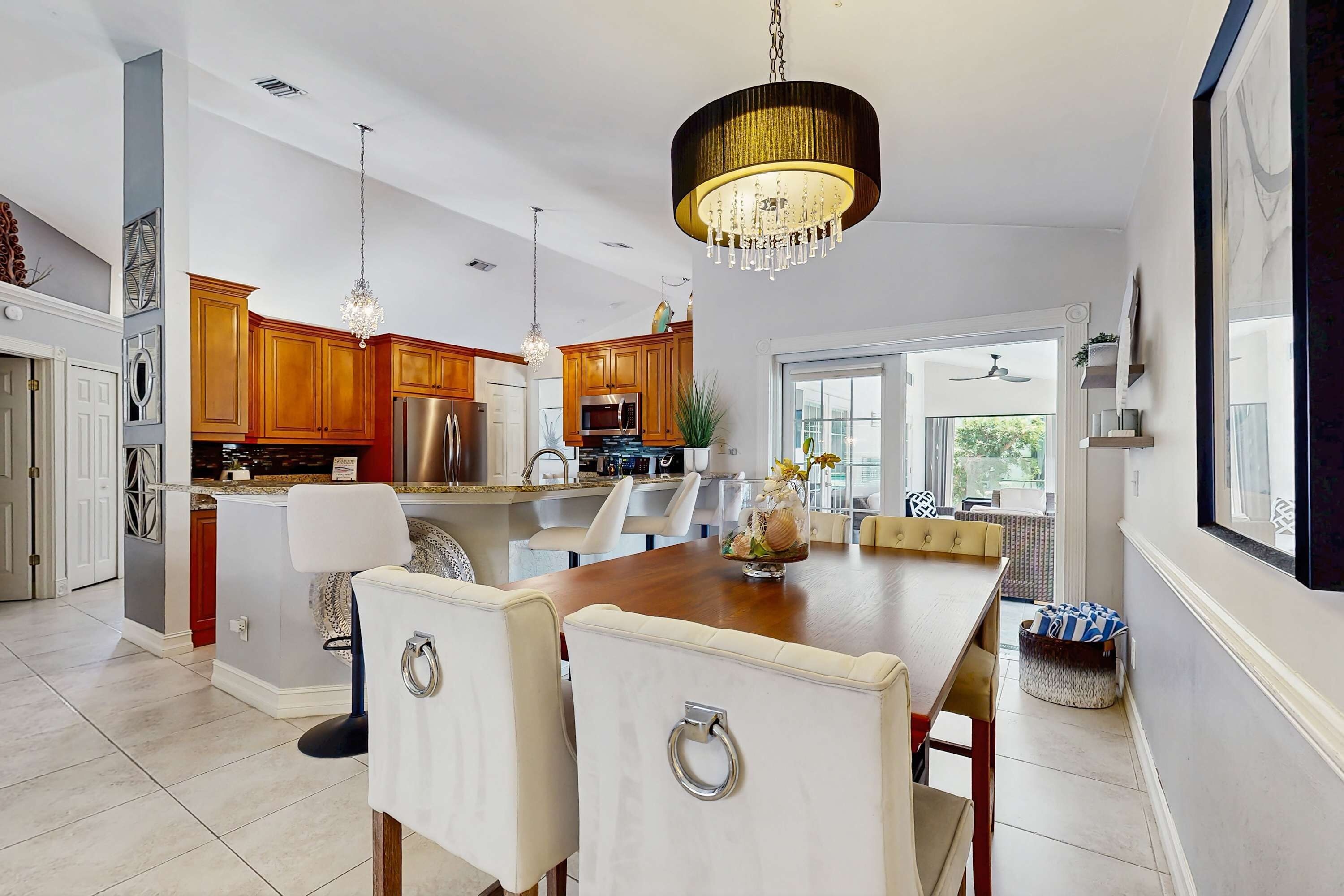A modern kitchen with wooden cabinets, a large island, and pendant lighting.
