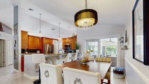 Une cuisine moderne avec des meubles en bois, un grand îlot central et des luminaires suspendus.