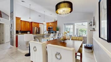 A modern kitchen with wooden cabinets, a large island, and pendant lighting.