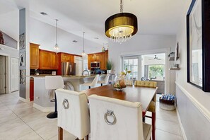 Una cocina moderna con armarios de madera, una isla grande e iluminación colgante.