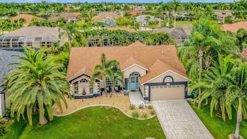 A residential area with houses, palm trees, and a driveway.