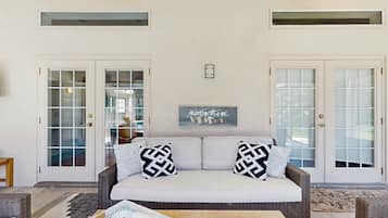 A living room with a sofa, two patterned pillows, a coffee table, and a framed picture on the wall.