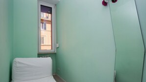 A room with a single bed, a window, and a radiator. - Renovated 2-bedroom apartment in the heart of Pigneto – sleeps 4 (Roma)