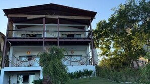 A two-story building with a flat roof, a balcony on the upper floor, and a stone pathway leading to the entrance. - Pousada Almaré Boipeba (Cairu)