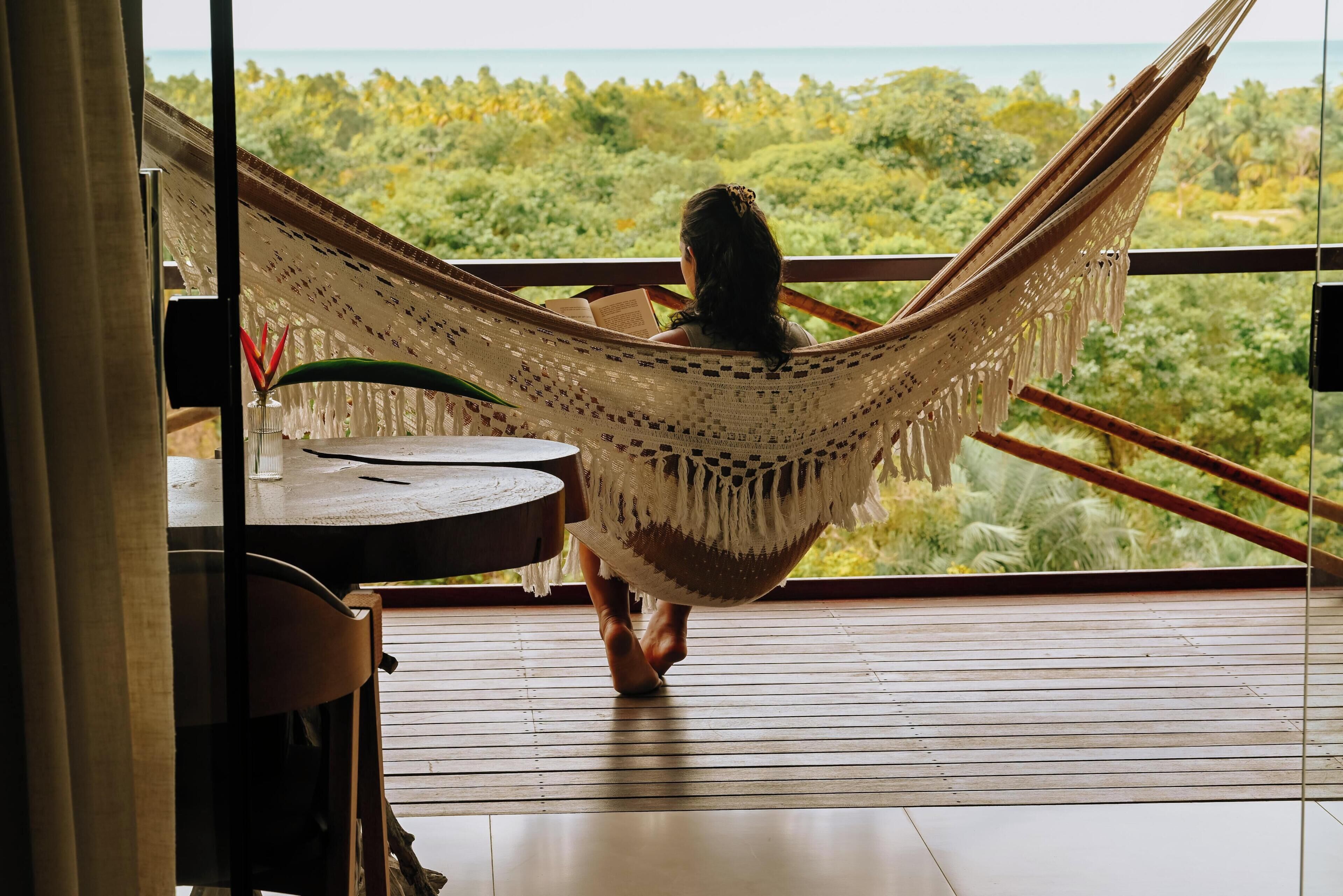 A hammock chair with a view of a tropical landscape.