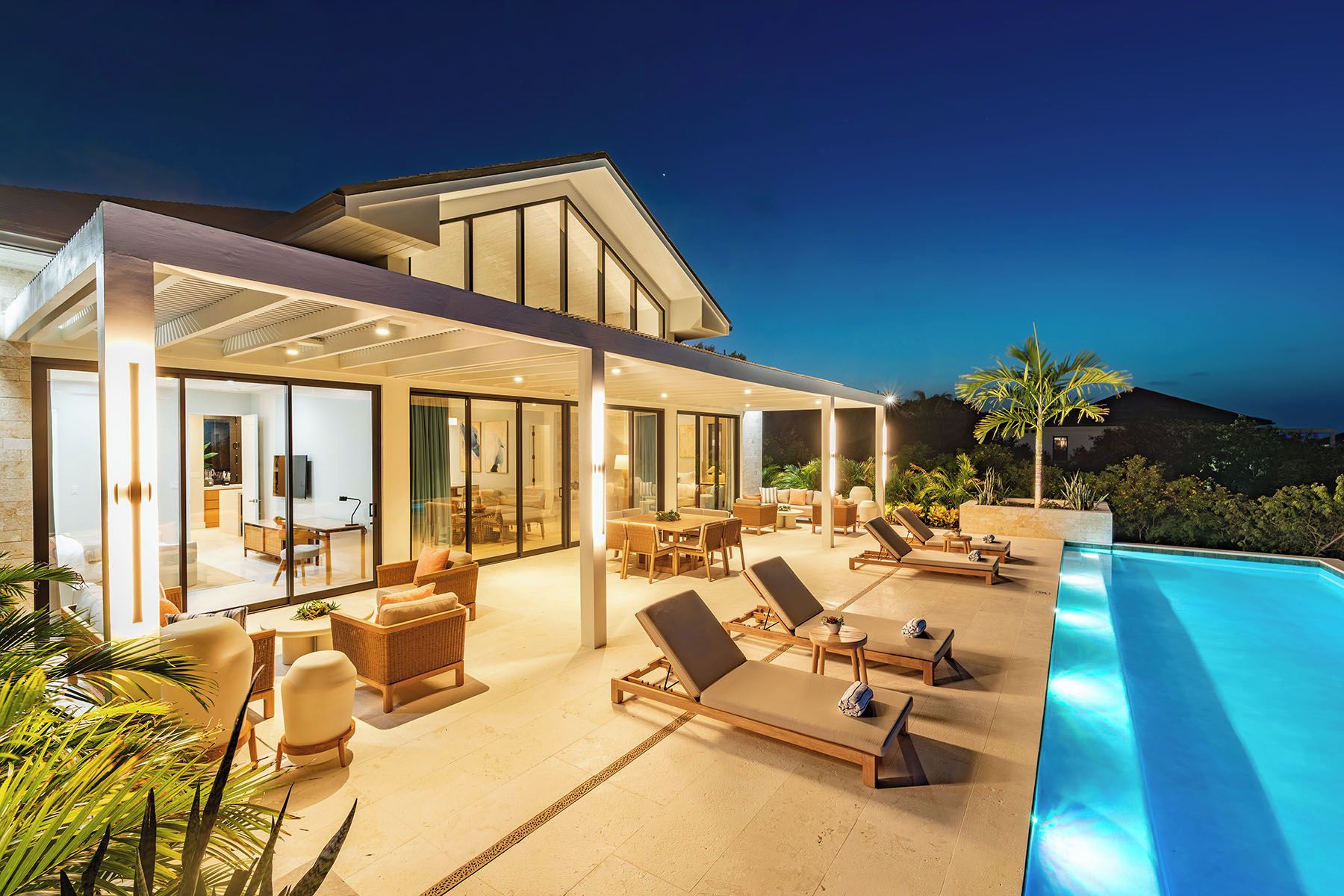 Et moderne hus med pool, udendørs møbler og udsigt til bakkerne.