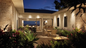 Eine moderne Außenpatio mit Essbereich, Feuerstelle und Meerblick.