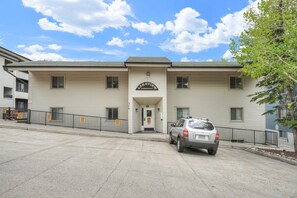 Ein zweistöckiges Gebäude mit einem Schild, auf dem 'Lakeview Condominiums' steht. Vor dem Gebäude ist ein Auto geparkt, und das Grundstück wird von einem Zaun umgeben.