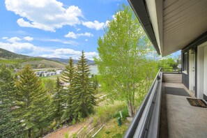 A balcony with a view of a residential area, trees, and a distant body of water. - Cozy Lake Dillon Condo: Perfect For Leaf Peeping! (Dillon)