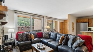 Een moderne woonkamer met een leren bank, een salontafel en uitzicht door grote ramen.
