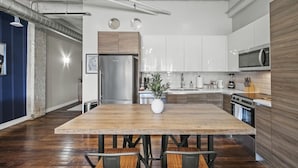 Una cocina moderna con una isla central, electrodomésticos de acero inoxidable y suelo de madera.