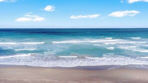 Una spiaggia con acque cristalline e una battigia sabbiosa.