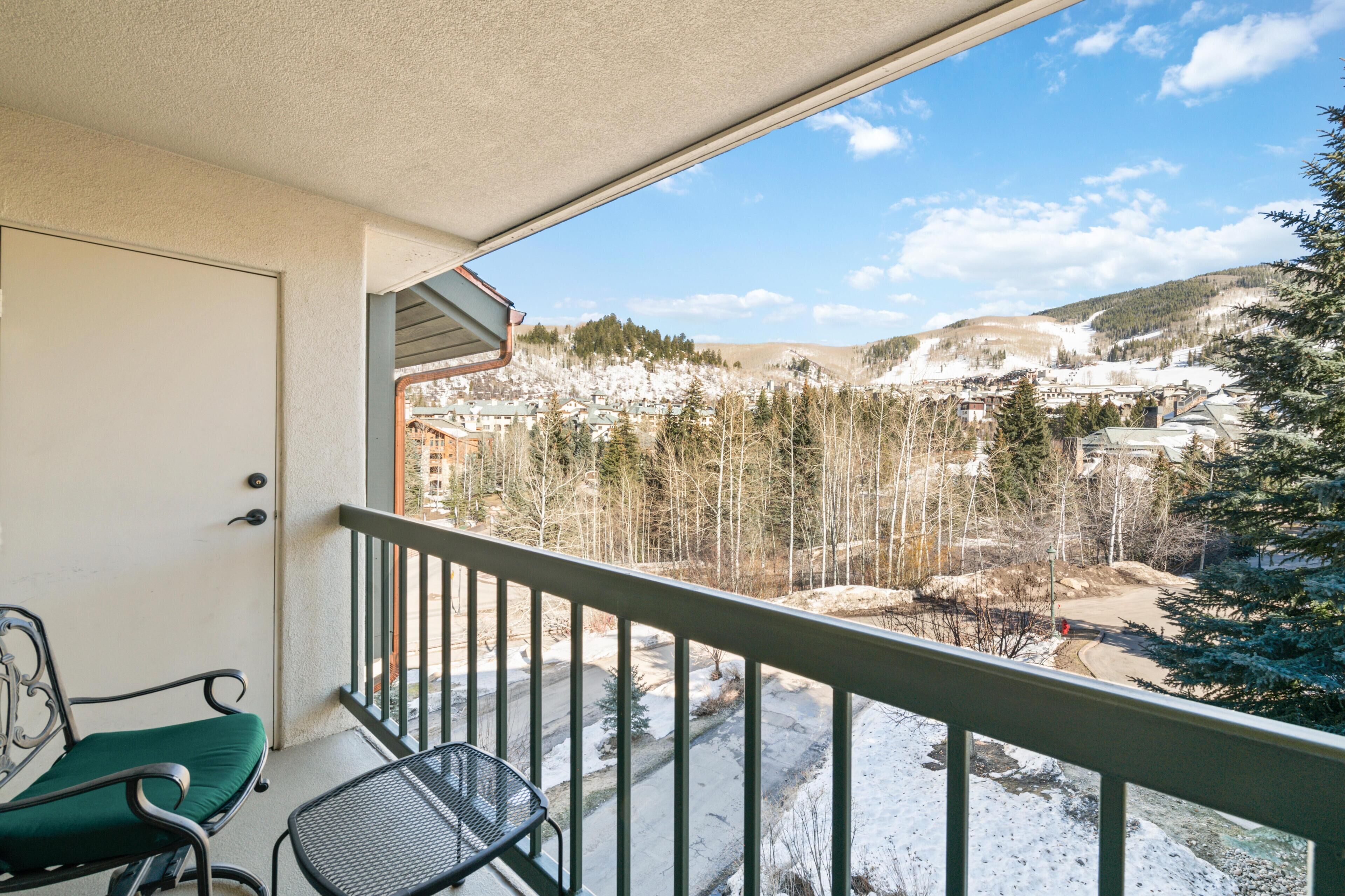 A balcony with a view of a snowy landscape and buildings.