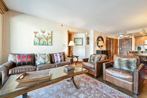 A living room with a glass coffee table, leather sofas, and a rug. - Borders Lodge L308 2BD Beaver Creek Ski-in, Ski-out Condo (Avon)