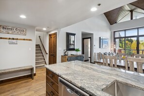 Eine Küche mit einer Granit-Arbeitsplatte, Holzschränken und einem Essbereich mit Tisch und Stühlen.