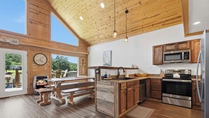 Een ruime keuken met houten kastjes, een groot kookeiland en uitzicht op de omgeving.