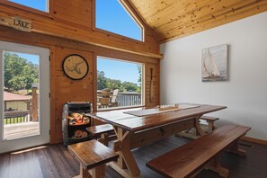 A wooden interior with a large table and benches, a clock, and a sailboat painting. - Sleeps 7, Waterfront, Dock, Great Water, Paddleboard, Firepit + More! (Sparta)