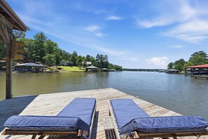 A wooden dock with two lounge chairs and a view of a lake. - Sleeps 7, Waterfront, Dock, Great Water, Paddleboard, Firepit + More! (Sparta)