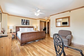 A bedroom with a wooden floor, a bed with white linens, a ceiling fan, a chair, and a mirror on the wall. - Borders Lodge L400 Hotel Room Beaver Creek Ski-in, Ski-out Condo (Avon)