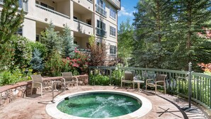 A multi-story building with a swimming pool, outdoor seating, and lush greenery. - Borders Lodge L400 Hotel Room Beaver Creek Ski-in, Ski-out Condo (Avon)