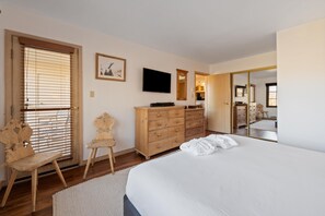A bedroom with a bed, wooden dresser, TV, and a mirror. - Borders Lodge L403 2BD Beaver Creek Ski-in, Ski-out Condo (Avon)