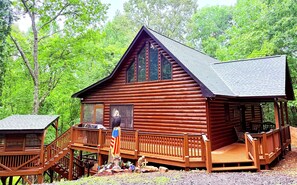 Eine Blockhütte mit Veranda, einer Terrasse und einer kleinen Sitzecke im Freien.