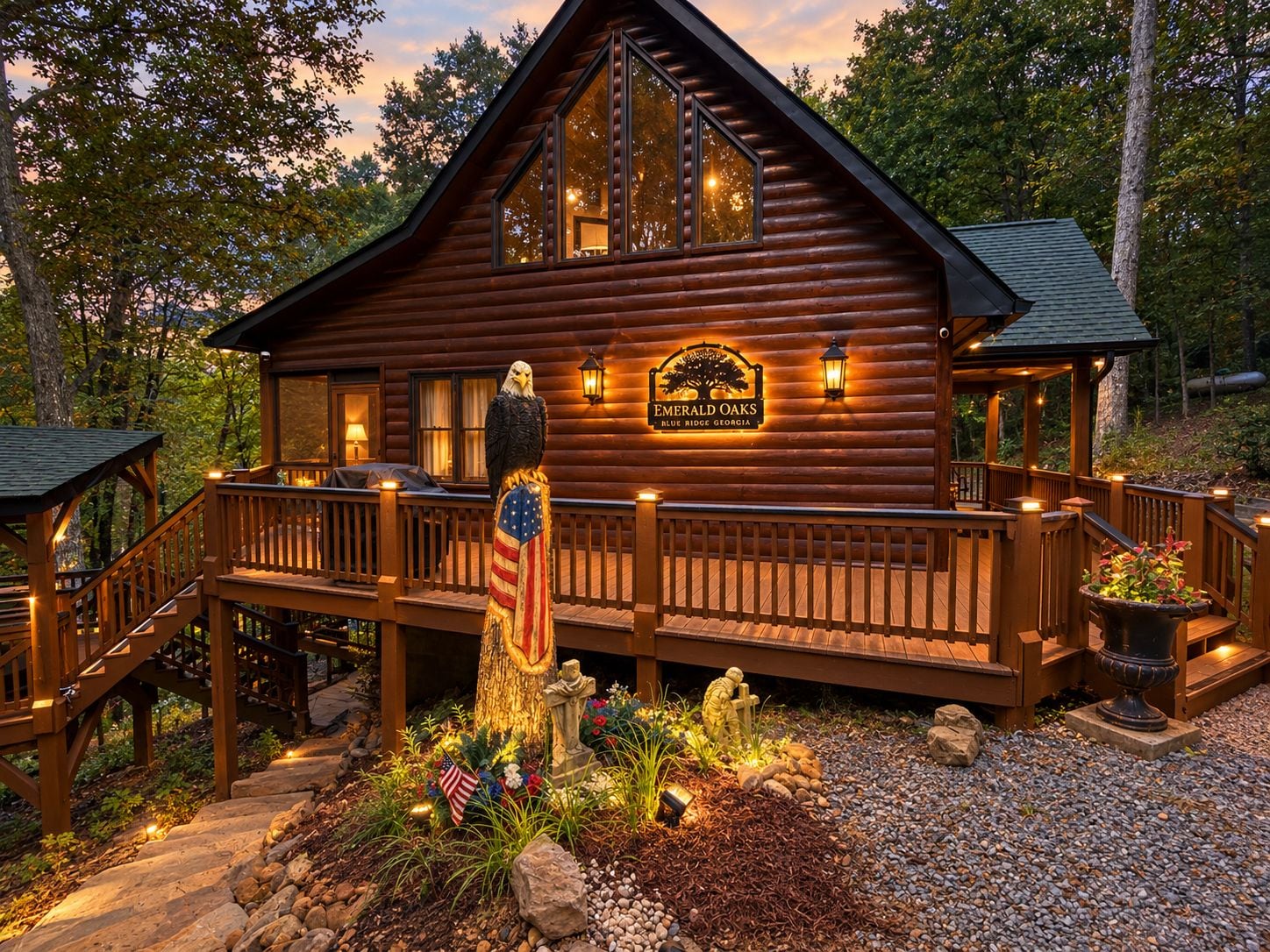 A log cabin with a deck, an American flag, and a sign that reads 'Emerald Oaks Blue Ridge Georgia'.