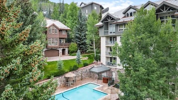 A residential area with a swimming pool, stone walls, and multiple houses with balconies.