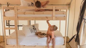 A bunk bed with two levels, a pillow with a wild cat design, and a box on the lower bunk.
