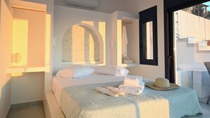 Ein Schlafzimmer mit Bett, Handtuch, Hut und Fenster.