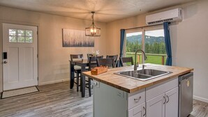 A compact kitchen with a wooden countertop, a built-in sink, and a dishwasher.