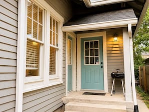 A house with a teal front door, white window frames, and a small porch with steps. - Historic Downtown Duplex - Fire Pit, Gym & Parking (Indianapolis)