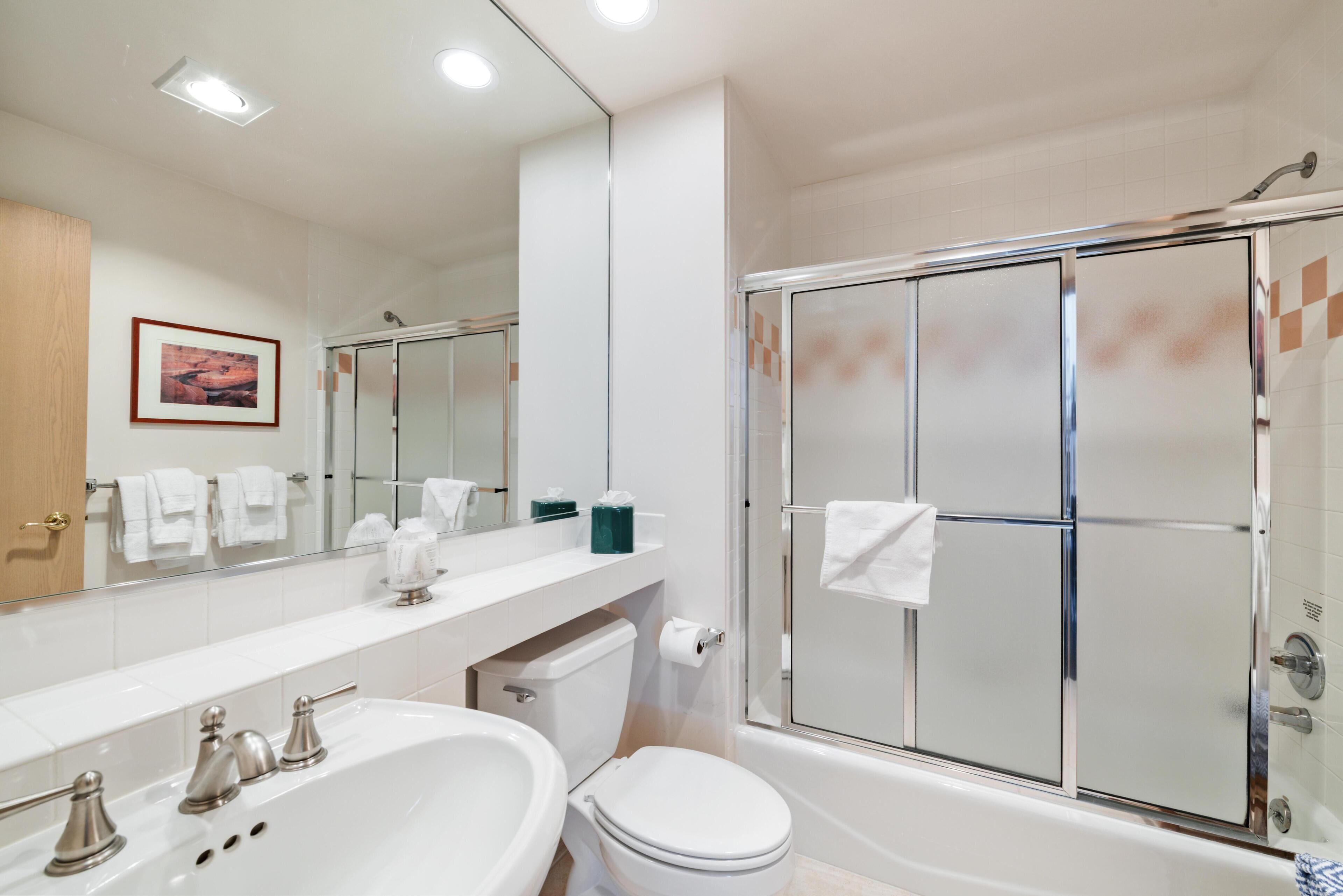 A bathroom with a bathtub, toilet, and shower.