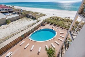 Ein Pool auf dem Dach mit Liegestühlen und Blick auf den Strand.