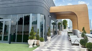 A modern building with a curved facade, large glass windows, and a checkered floor. - Luxury Designer Retreat in Wynwood / Skyline. 2BR. Pool & Bar (Miami)