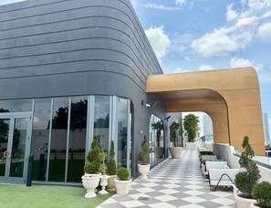 A modern building with a curved facade, large glass windows, and a checkered floor. - Luxury Designer Retreat in Wynwood / Skyline. 2BR. Pool & Bar (Miami)