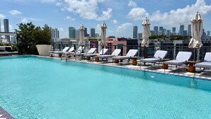A rooftop pool with lounge chairs and umbrellas, a city skyline in the background. - Luxury Designer Retreat in Wynwood / Skyline. 2BR. Pool & Bar (Miami)