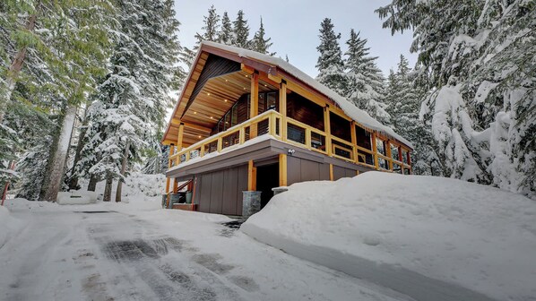 Eine Holzhütte mit Balkon und verschneiter Landschaft.