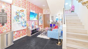 A modern interior with a staircase, artwork on the walls, a coffee bar, and a blue sofa. - II. Chic 4BR Home by Universal + Patio + Grill + Parking (Los Angeles)