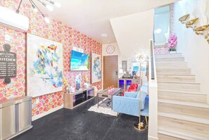 A modern interior with a staircase, artwork on the walls, a coffee bar, and a blue sofa. - II. Chic 4BR Home by Universal + Patio + Grill + Parking (Los Angeles)